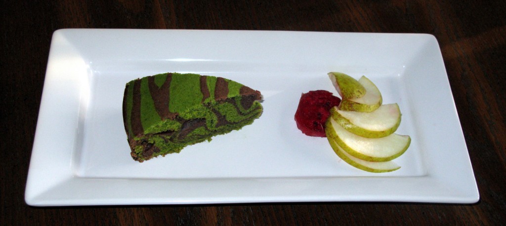 Slice of matcha and chocolate zebra cake with pear and cactus pear slices