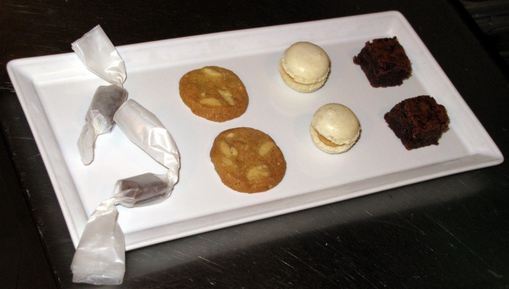 Mignardises, from left to right: caramel confections, white chocolate chip sablés, macarons, and cinnamon chocolate brownies